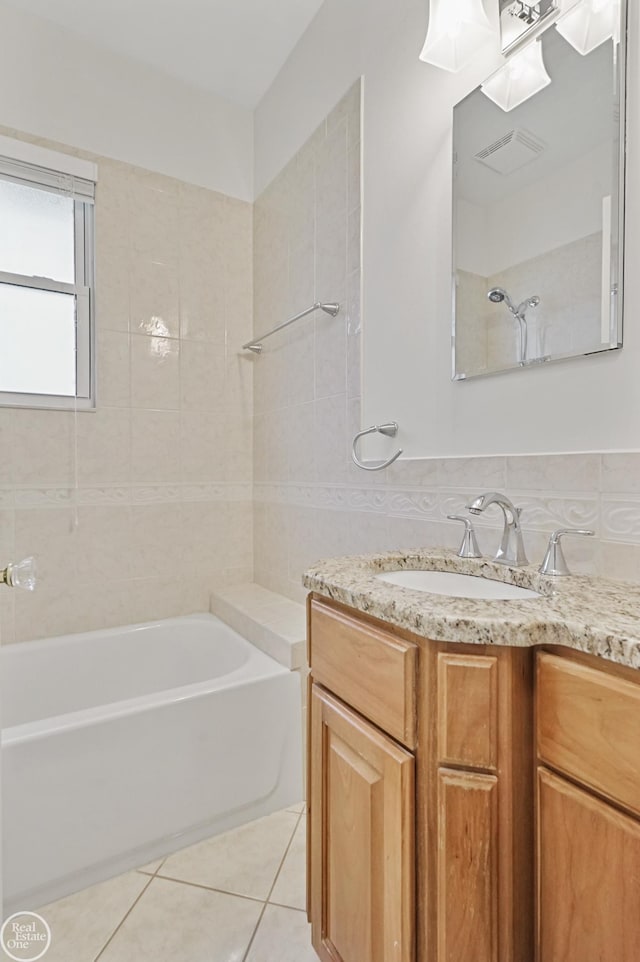 bathroom featuring tile patterned floors, vanity, and tiled shower / bath