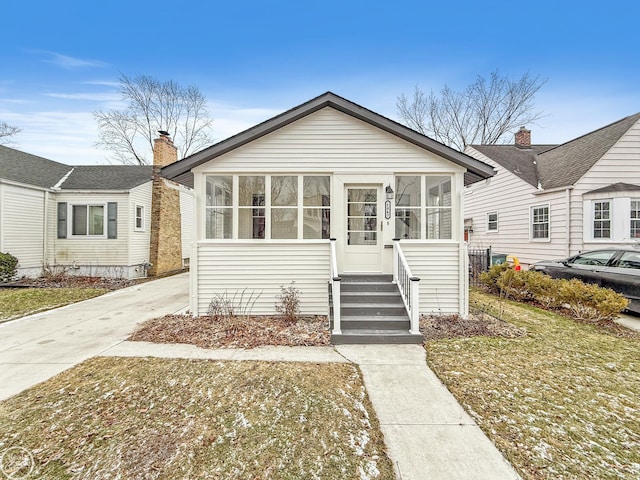 view of front of property with a sunroom and a front lawn