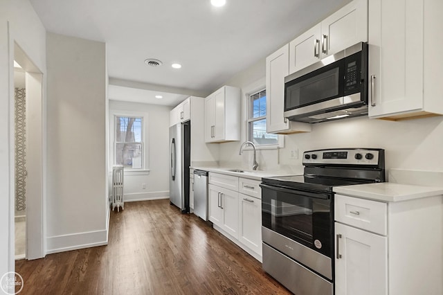 kitchen with a wealth of natural light, sink, white cabinets, and stainless steel appliances