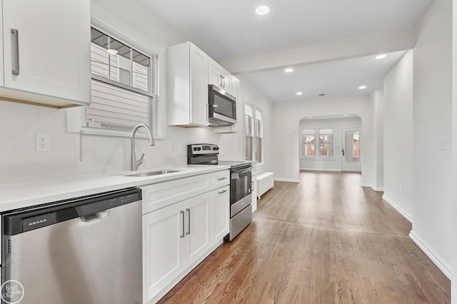 kitchen featuring white cabinetry, sink, hardwood / wood-style flooring, and appliances with stainless steel finishes