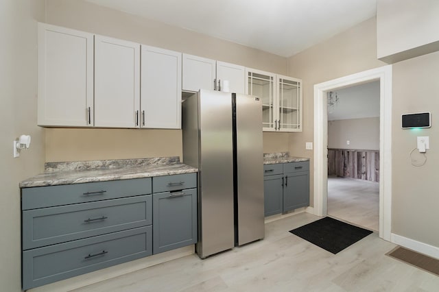 kitchen featuring light hardwood / wood-style flooring, white cabinetry, stainless steel refrigerator, and gray cabinetry