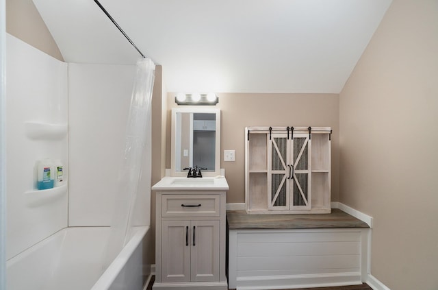 bathroom featuring vanity, shower / bath combination with curtain, and vaulted ceiling