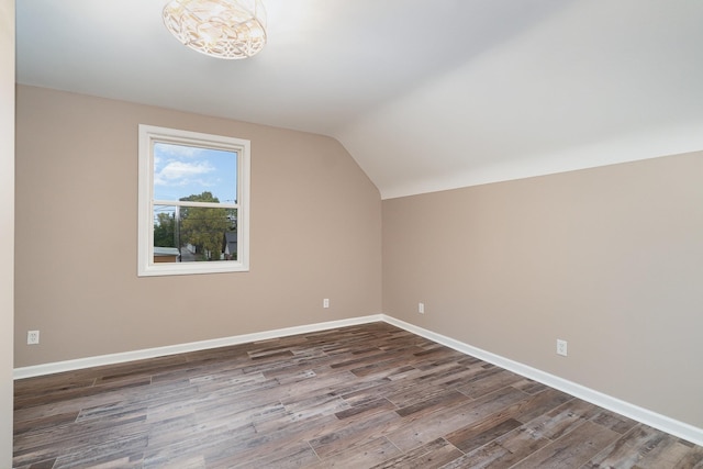 additional living space with dark hardwood / wood-style flooring and vaulted ceiling