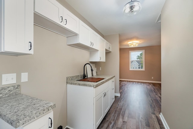 kitchen with dark hardwood / wood-style flooring, white cabinetry, and sink