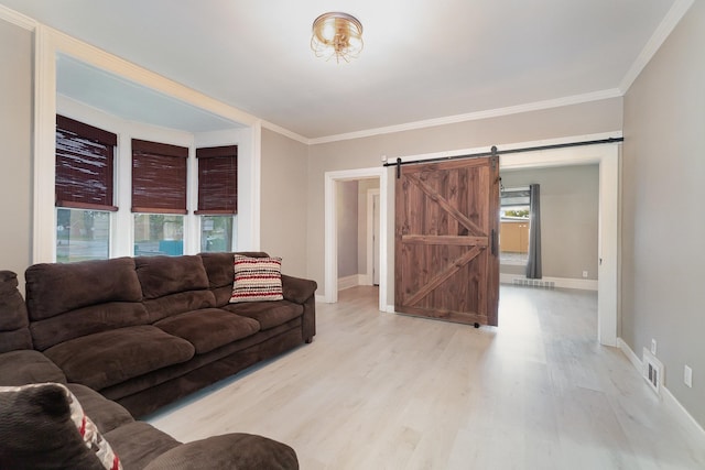 living room featuring a barn door, crown molding, and light wood-type flooring