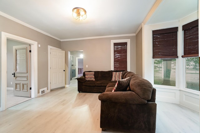 living room with light wood-type flooring and crown molding