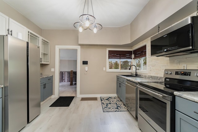 kitchen featuring appliances with stainless steel finishes, gray cabinetry, sink, a notable chandelier, and white cabinetry