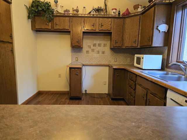 kitchen with tasteful backsplash, white appliances, sink, and dark wood-type flooring