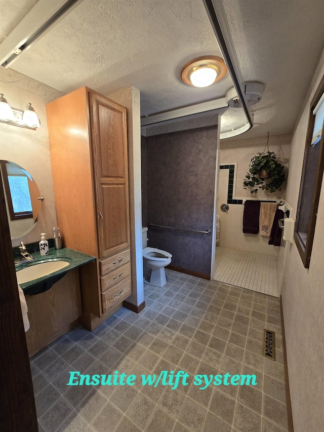 bathroom featuring a textured ceiling, vanity, and toilet