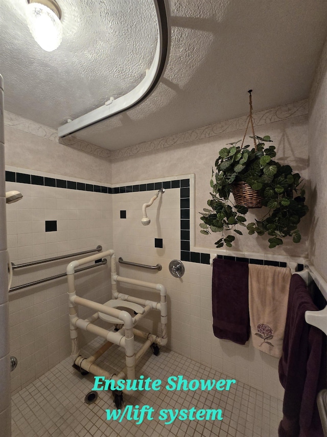 bathroom with a textured ceiling, tile walls, and tile patterned floors