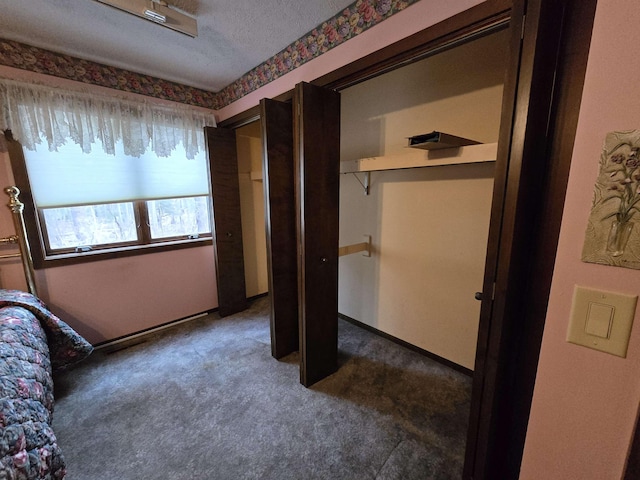 unfurnished bedroom featuring dark colored carpet and a textured ceiling