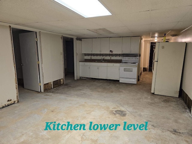 kitchen with a paneled ceiling, white cabinetry, sink, and white appliances