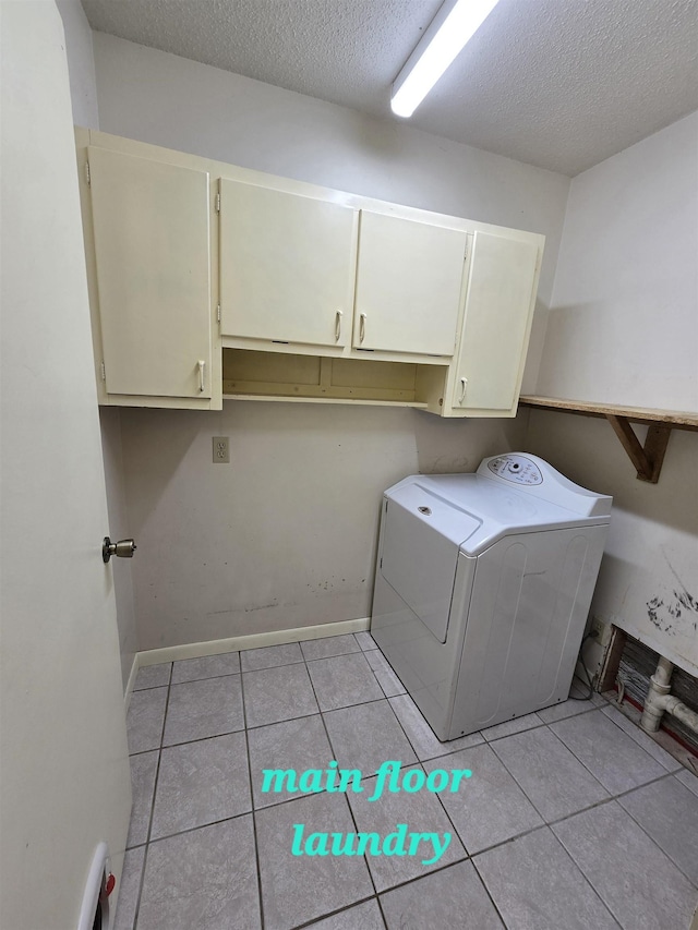 laundry area with cabinets, washer / dryer, light tile patterned floors, and a textured ceiling