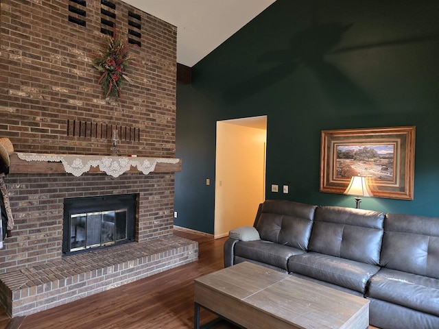 living room featuring a fireplace, high vaulted ceiling, and wood-type flooring