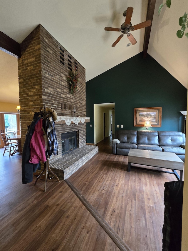 living room featuring a fireplace, hardwood / wood-style floors, lofted ceiling with beams, and ceiling fan