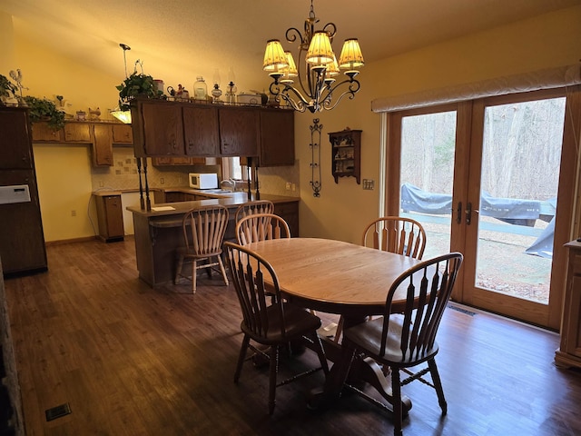 dining room with french doors, dark hardwood / wood-style floors, and a notable chandelier