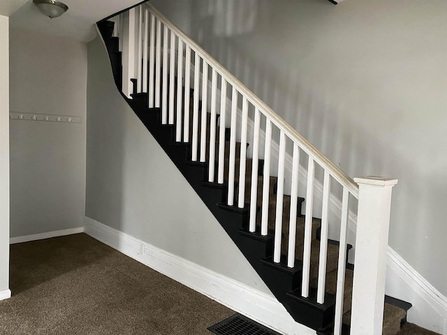 staircase featuring carpet