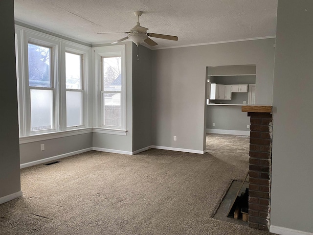 unfurnished living room featuring carpet, ceiling fan, ornamental molding, and a textured ceiling