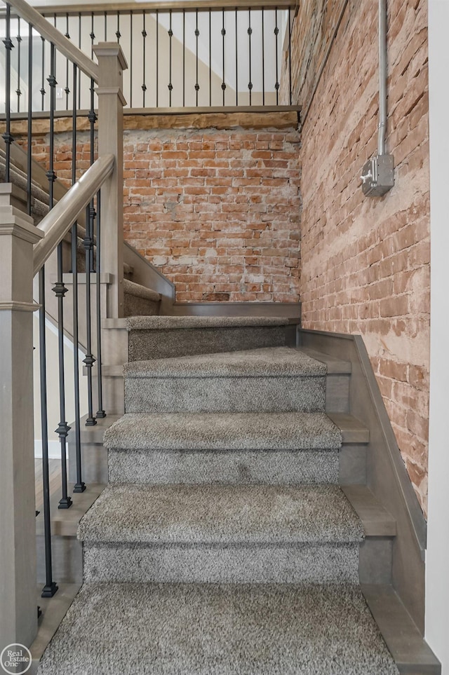 stairs with a high ceiling and brick wall