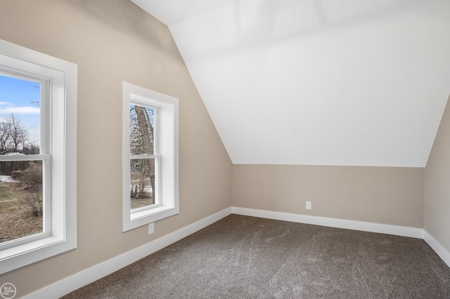 additional living space featuring carpet floors, vaulted ceiling, and a healthy amount of sunlight