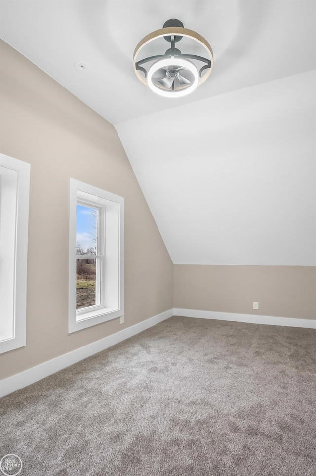 additional living space featuring lofted ceiling and carpet