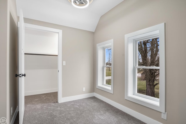 unfurnished bedroom featuring carpet floors and vaulted ceiling