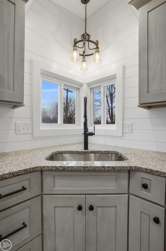 details with light stone counters, sink, and gray cabinets