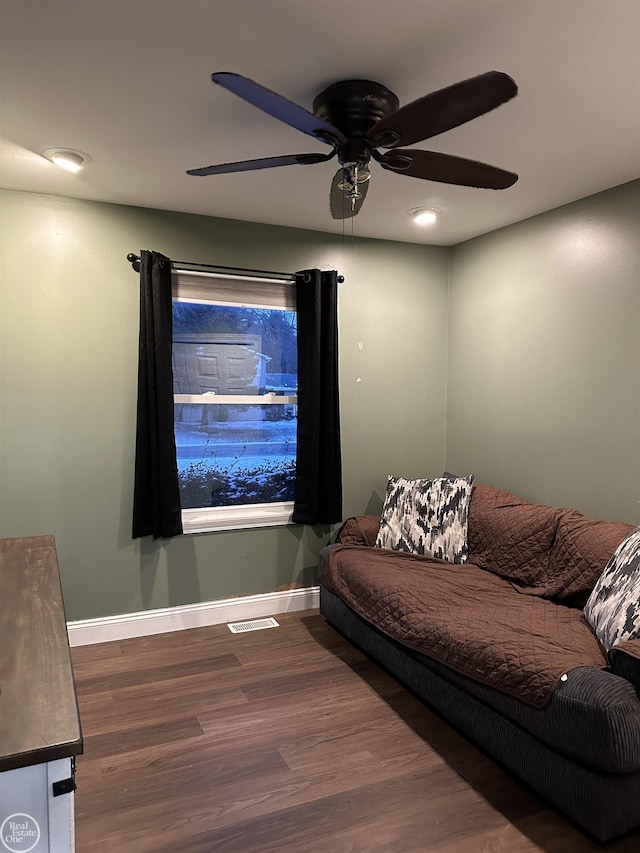 living room featuring ceiling fan and dark wood-type flooring