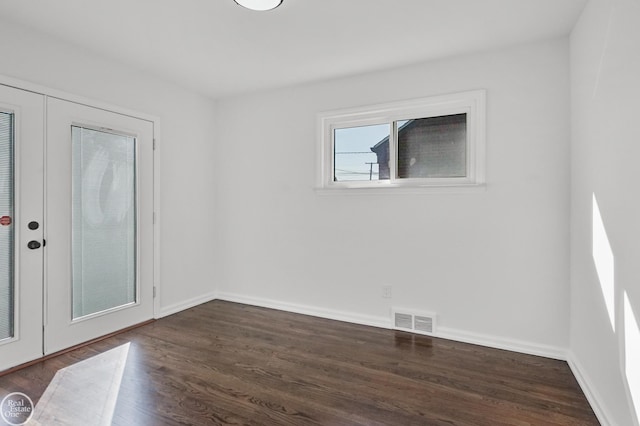 empty room featuring french doors and dark hardwood / wood-style floors