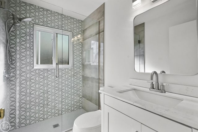 bathroom featuring vanity, toilet, and a shower with shower door