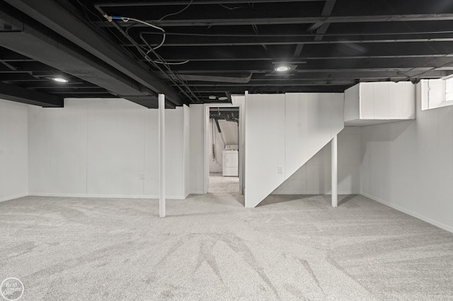 basement featuring light colored carpet and washer / dryer