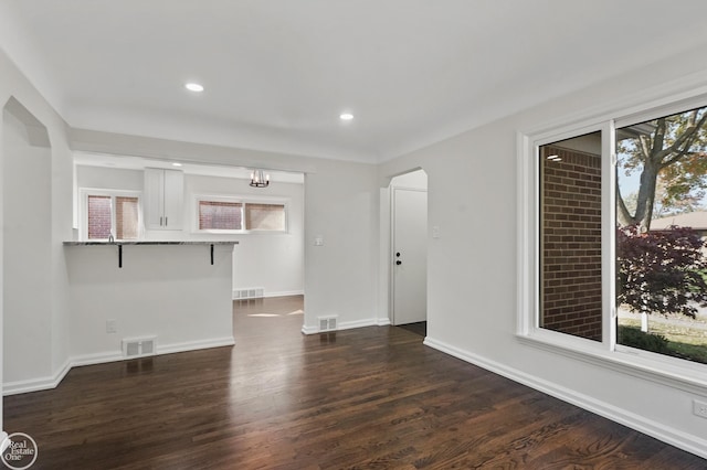 unfurnished living room with dark wood-type flooring