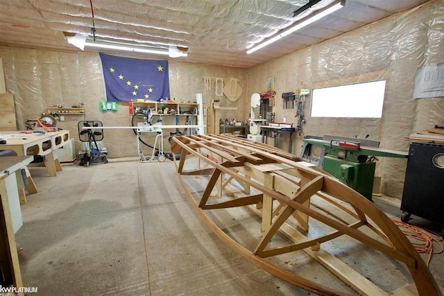 recreation room featuring a workshop area and concrete flooring