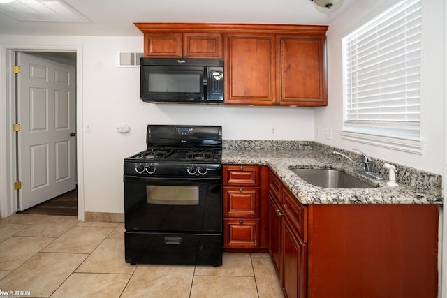 kitchen featuring light tile patterned floors, sink, light stone counters, and black appliances