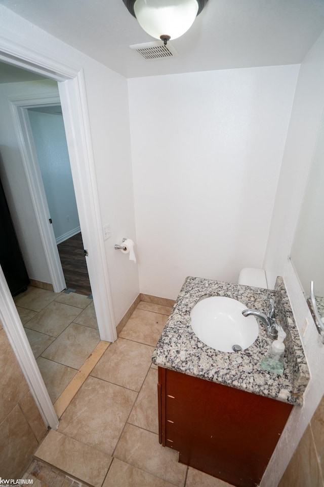 bathroom with tile patterned flooring, vanity, and toilet