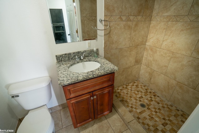 bathroom featuring tiled shower, vanity, and toilet