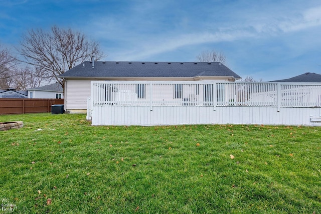 rear view of house featuring a yard, a deck, and central air condition unit