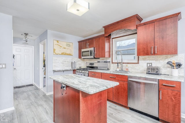 kitchen featuring a center island, sink, stainless steel appliances, and light hardwood / wood-style flooring