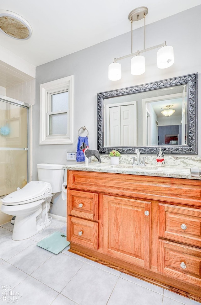 bathroom with toilet, vanity, tile patterned floors, and an enclosed shower