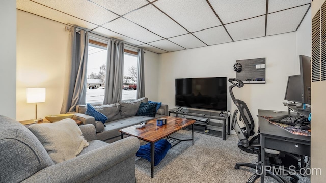 carpeted living room featuring a drop ceiling