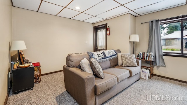 living room featuring light carpet and a drop ceiling