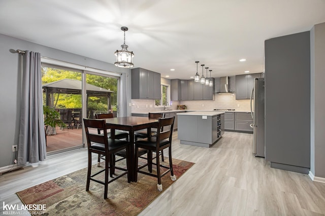 dining space with light hardwood / wood-style floors, sink, and a chandelier