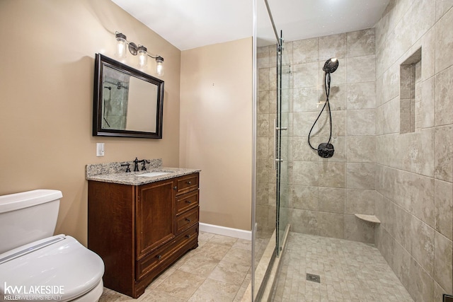 bathroom with vanity, a shower with shower door, and toilet