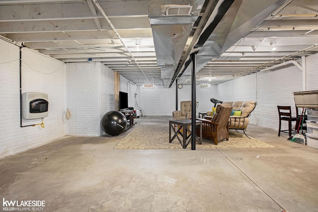 basement with heating unit and brick wall