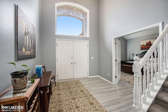 entrance foyer with a high ceiling and light wood-type flooring