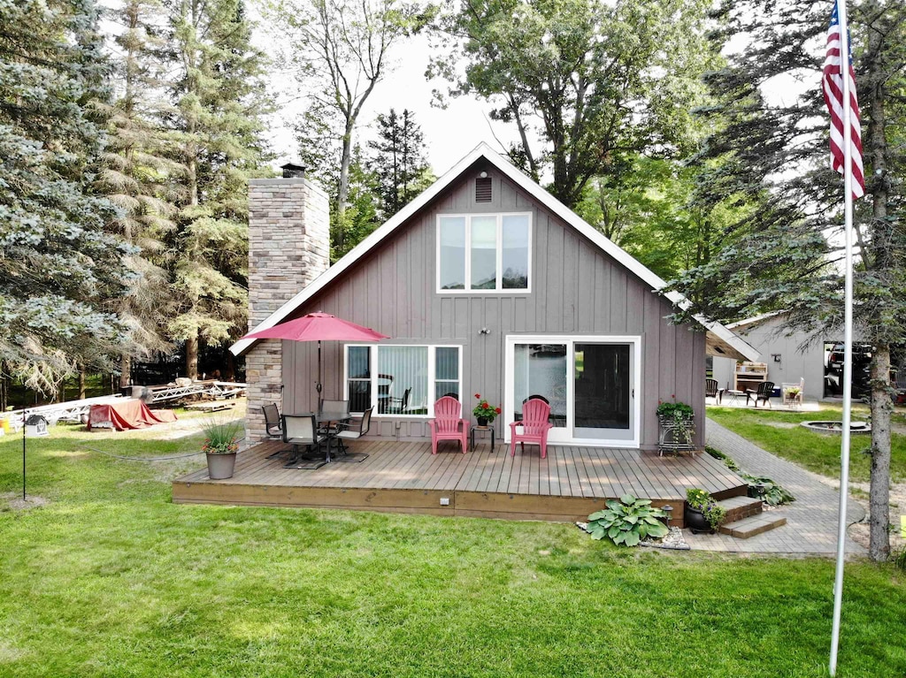 back of house with a lawn and a wooden deck