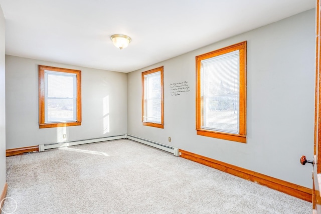 empty room with a wealth of natural light, carpet floors, and a baseboard heating unit