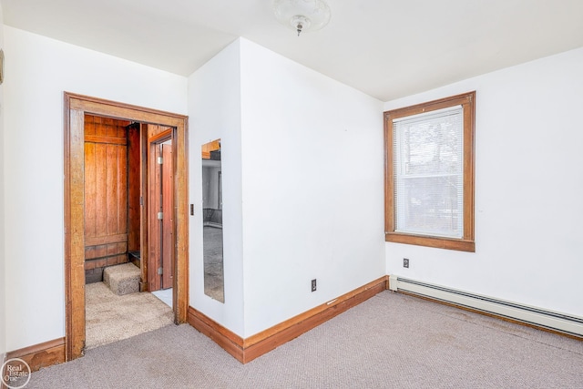 unfurnished room with baseboard heating and light colored carpet