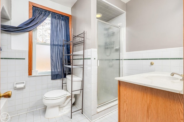 bathroom featuring tile patterned flooring, a shower with door, toilet, and tile walls