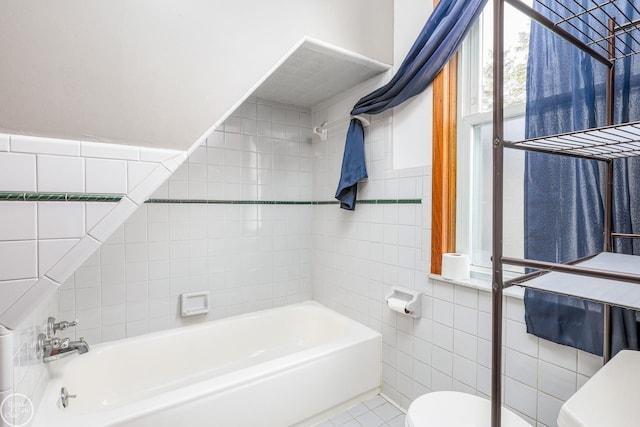 bathroom featuring tile patterned floors, tile walls, and toilet